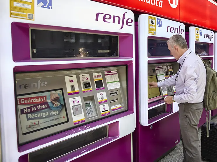 Una persona en una de las máquinas de venta de billetes.