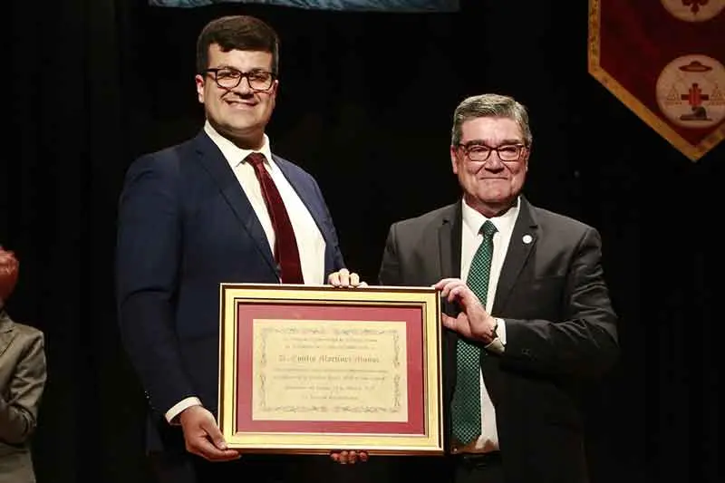 El pregonero, a la derecha, recibiendo el detalle conmemorativo de su intervención de manos del presidente de la Junta de Hermandades de Semana Santa