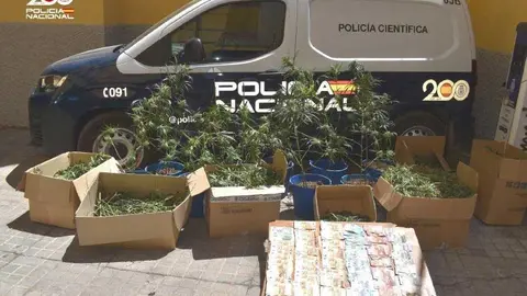 Un veh&iacute;culo de la Polic&iacute;a Nacional con el material y dinero incautado en el operativo.