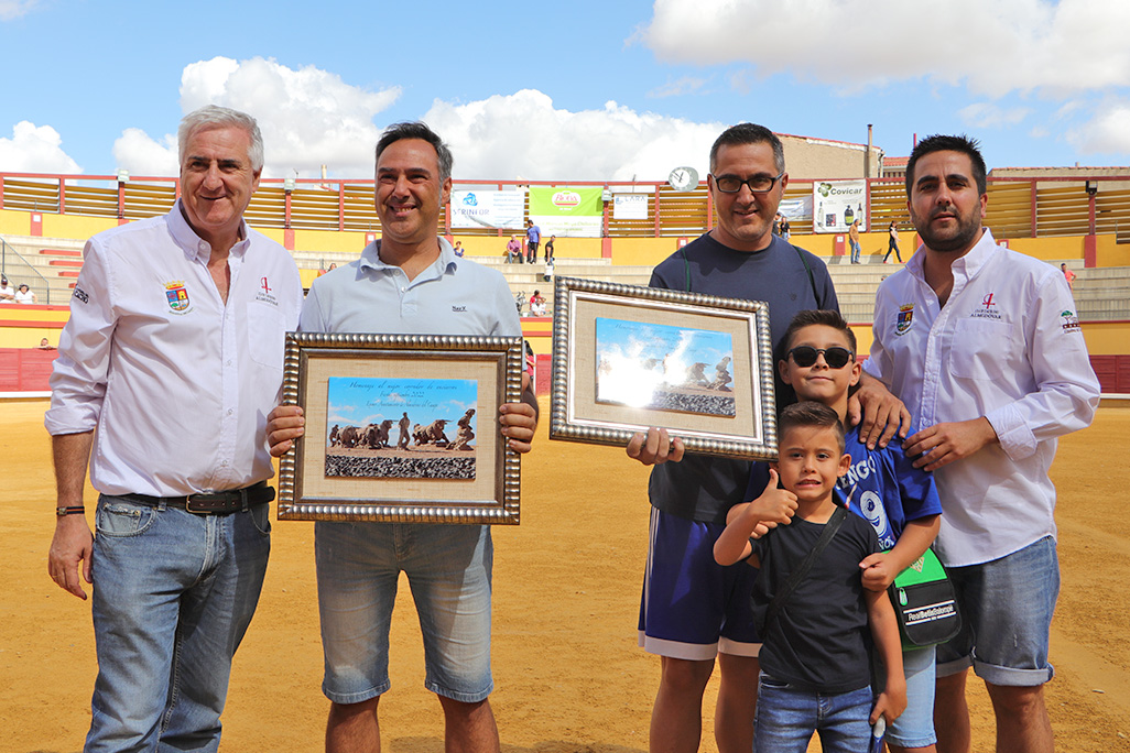 Ángel y Javier muestran en el centro los lienzo de su distinción honorífica de Corredores de Encierros 2022