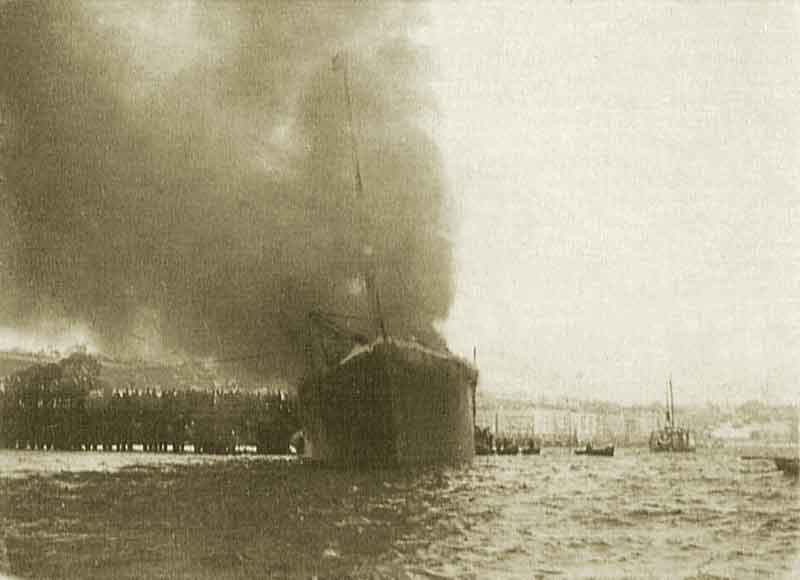 “Cabo Machichaco” incendiando en el muelle de Santander. Fuente: es.wikipedia.org